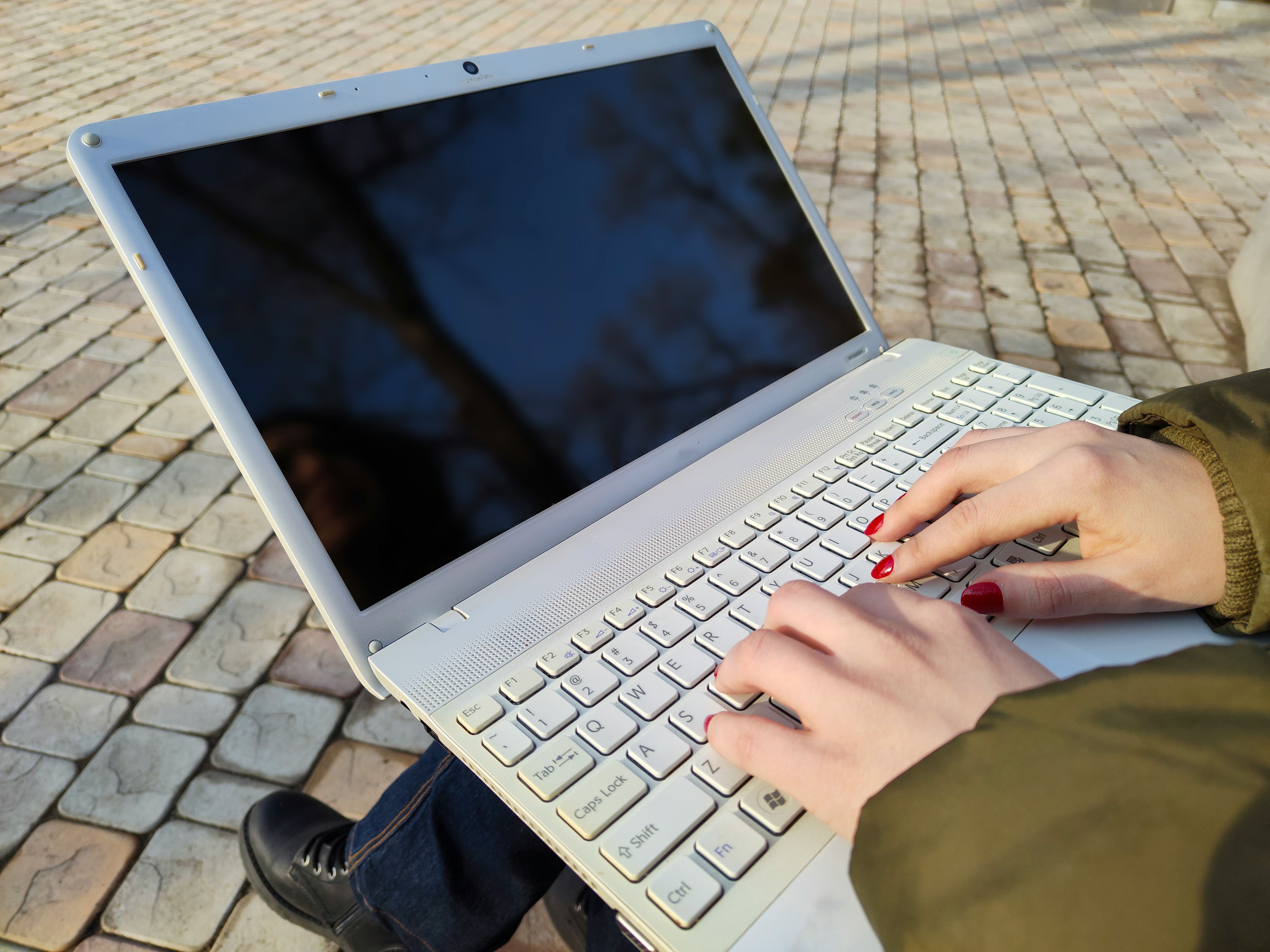 Close up of a laptop and a person's hands typing
