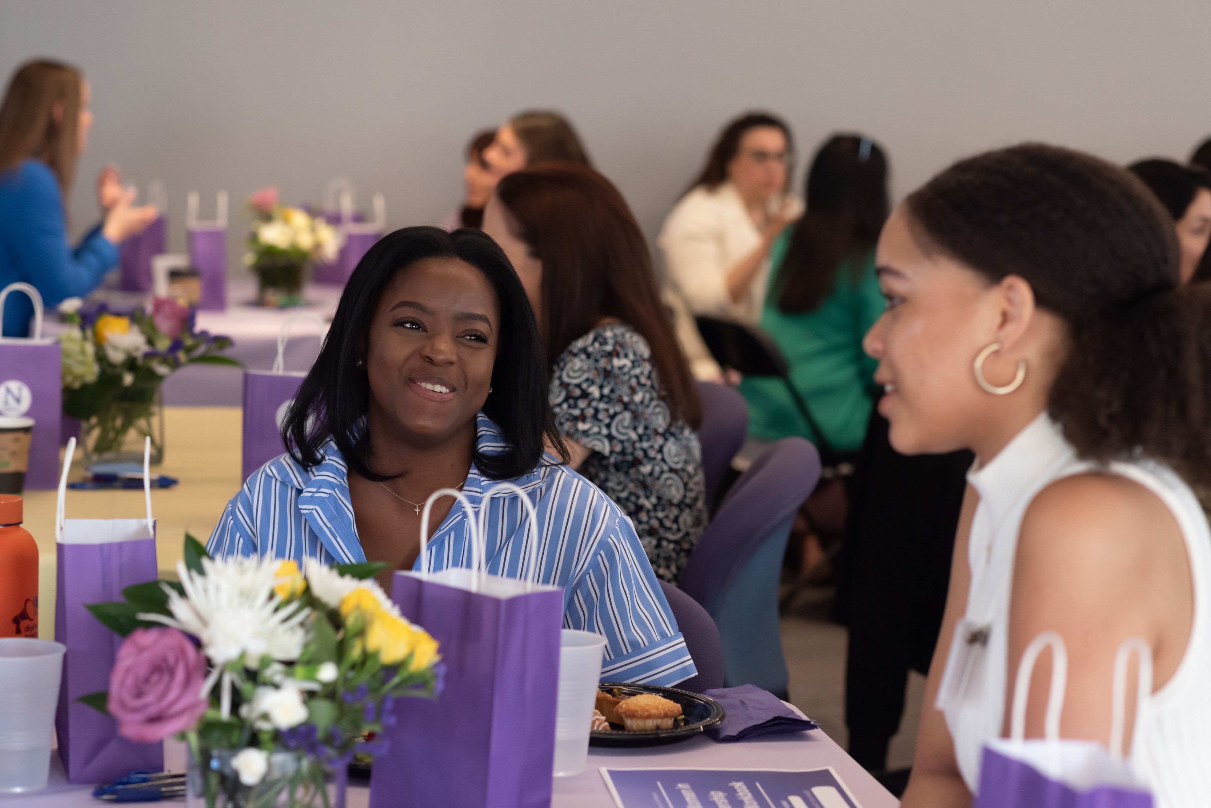 Two people talking and smiling while sitting at a table