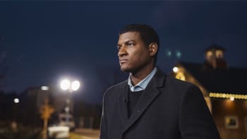 Omar Jimenez stands looking into the distance at nightfall