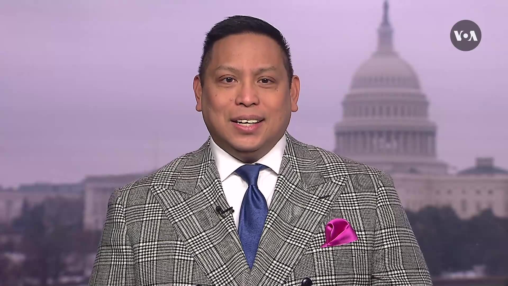 A person, Chris Casquejo, reports on camera dressed in a suit