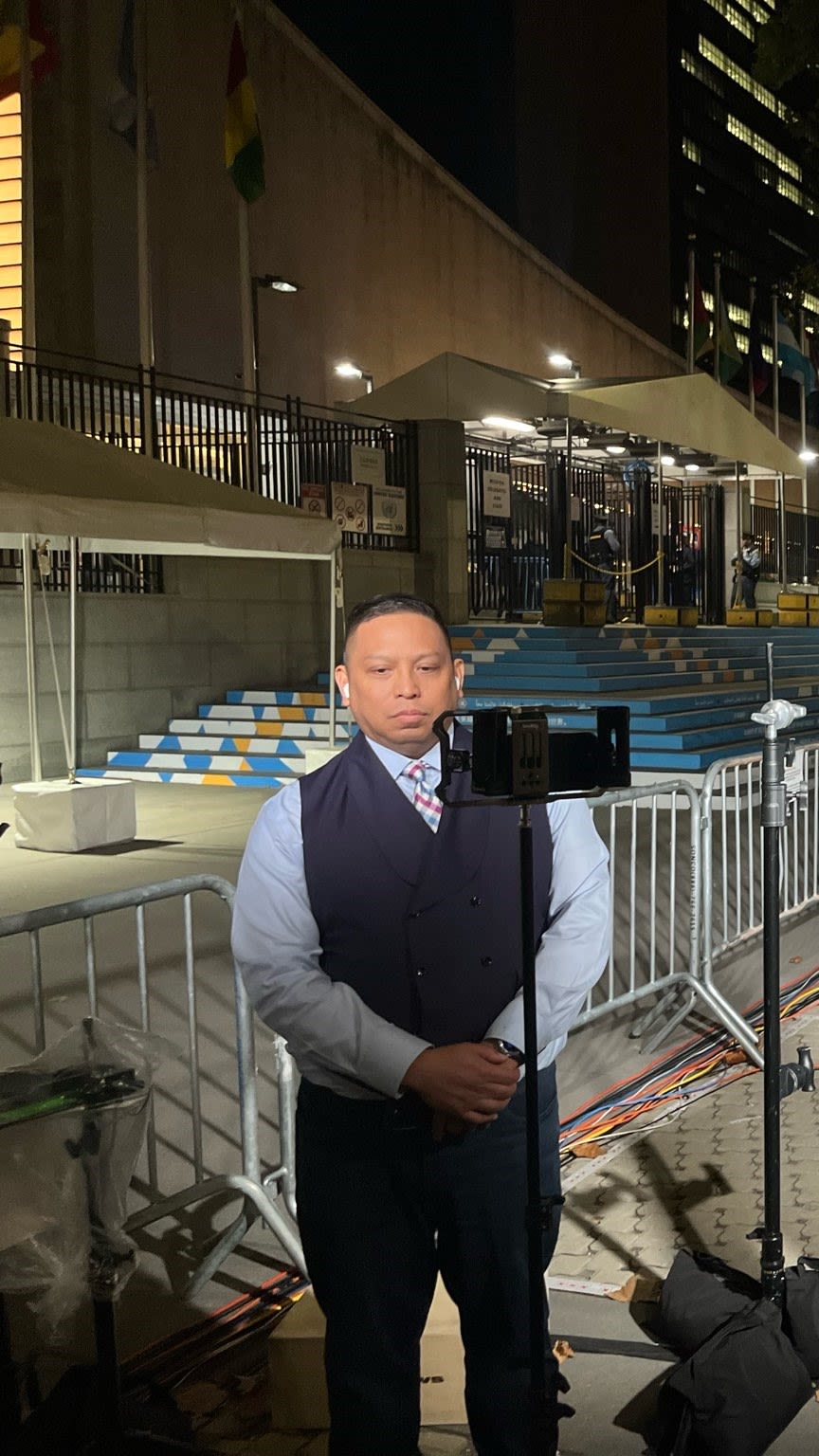 A person, Chris Casquejo, prepares to give a report in front of a camera